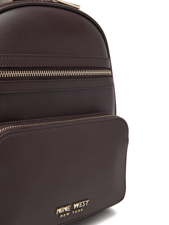 Zbliżenie na przednią część plecaka z widocznymi suwakami i kieszenią.
