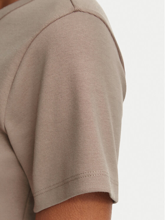 Zbliżenie na rękaw T-shirtu i ramię modelki.