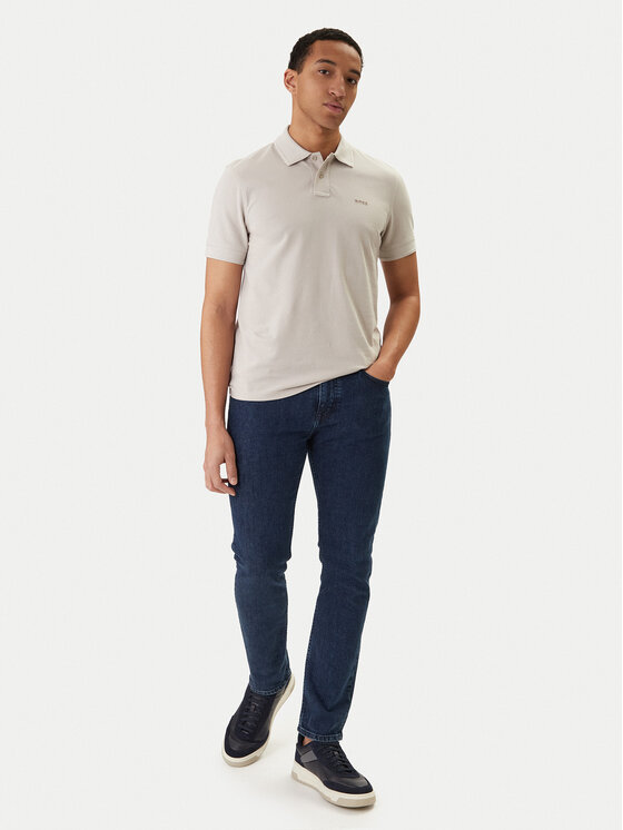 Model w koszulce polo i spodniach, ujęcie całej sylwetki podczas chodzenia.