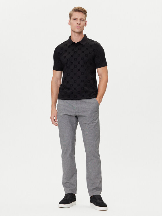 Model w koszulce polo i spodniach, widok całej sylwetki.