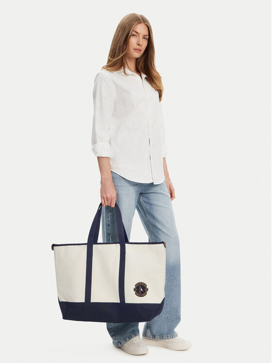 Modelka stojąca, trzyma duży shopper w dłoni.