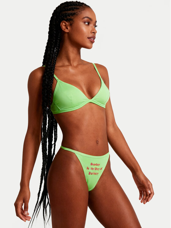 Modelka w komplecie bielizny, majtki typu string widoczne z przodu pod kątem.