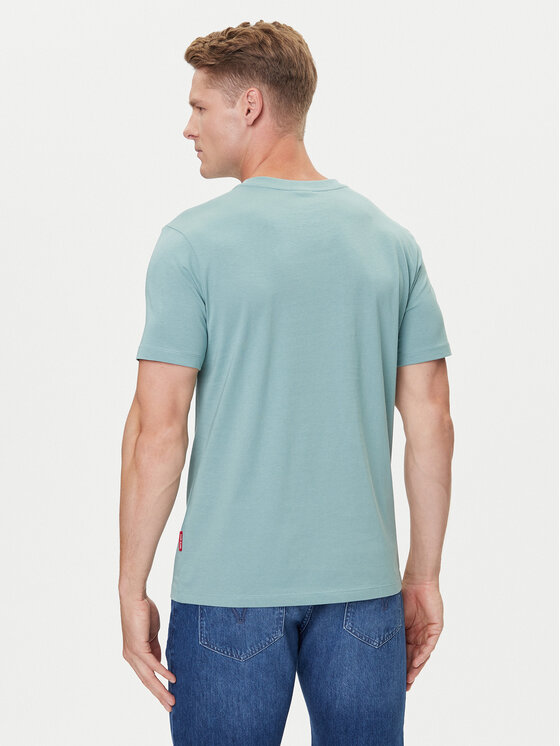Model w koszulce i jeansach pokazany od tyłu, ujęcie od kolan w górę.