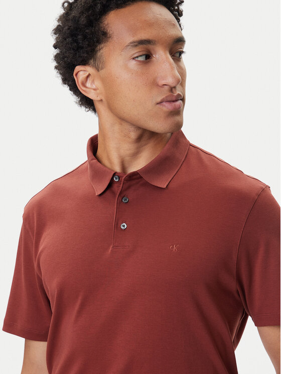 Model w koszulce polo, ujęcie portretowe z widoczną górną częścią tułowia.