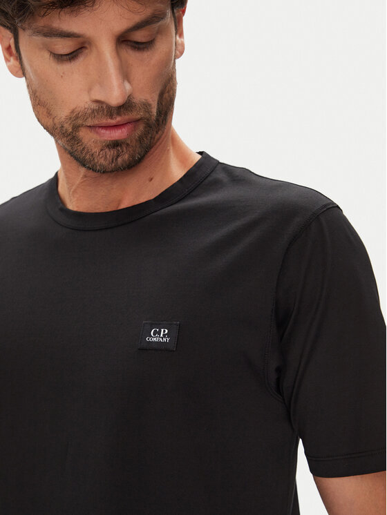 Zbliżenie na górną część T-shirtu na modelu.