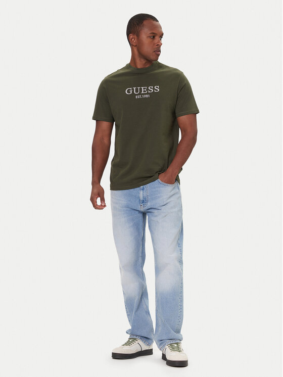 Model w T-shircie i dżinsach, ujęcie całej sylwetki.