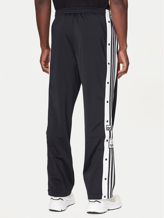 Model w spodniach sportowych, ujęcie nogawek od tyłu.
