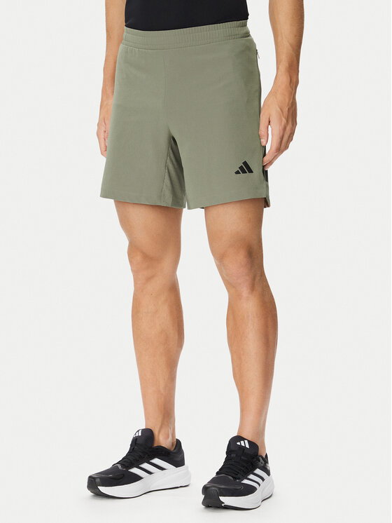 Model w szortach sportowych, ujęcie od przodu do połowy ud.
