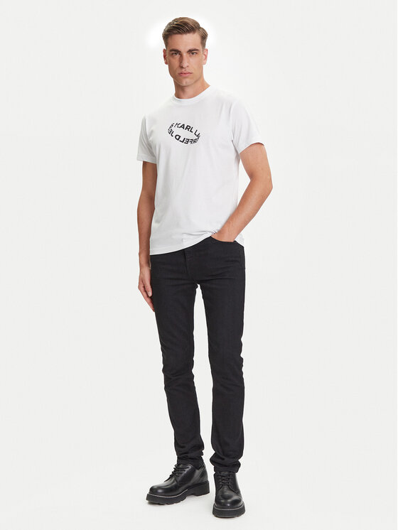 Model stojący, cała sylwetka, T-shirt i spodnie widoczne w kadrze.