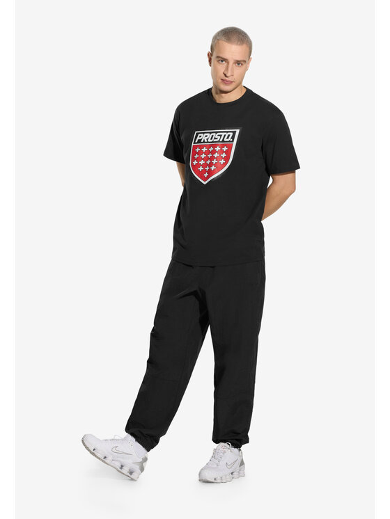 Model prezentujący t-shirt z nadrukiem, sylwetka w lekkim wykroku.