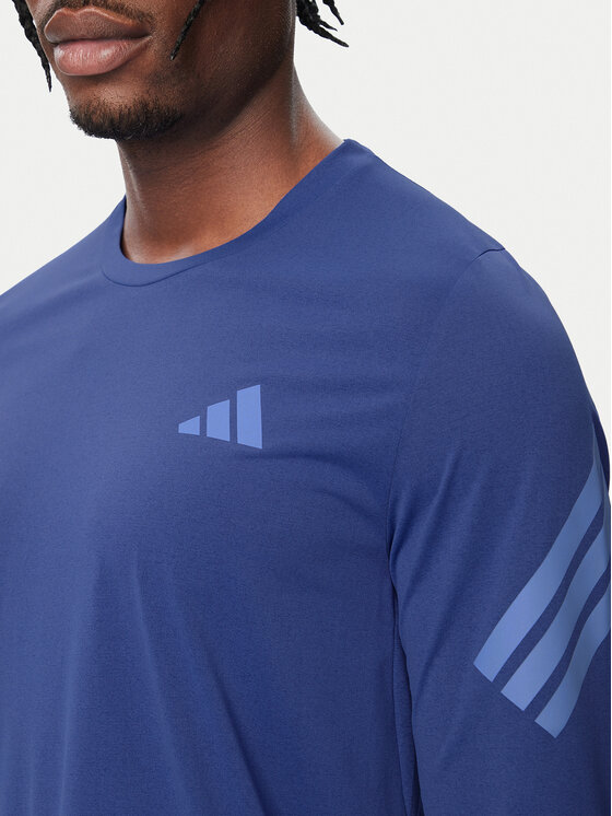 Zbliżenie na górną część bluzki z długim rękawem na modelu.