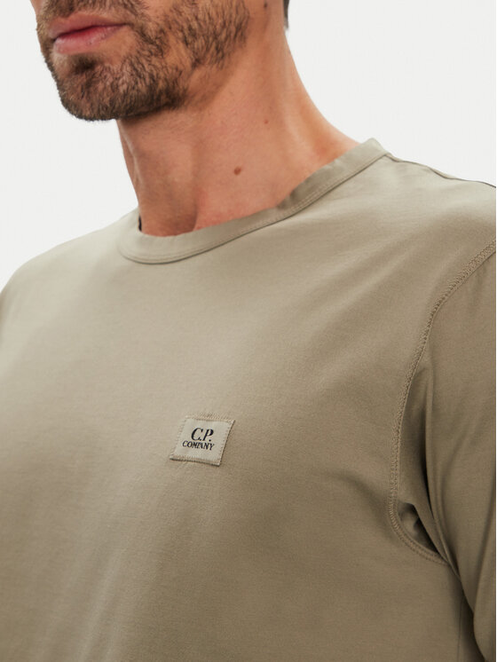 Zbliżenie na górną część t-shirtu na modelu, widoczny detal na piersi.