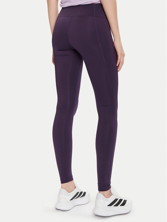 Modelka w legginsach sportowych, ujęcie od tyłu, sylwetka do kostek.