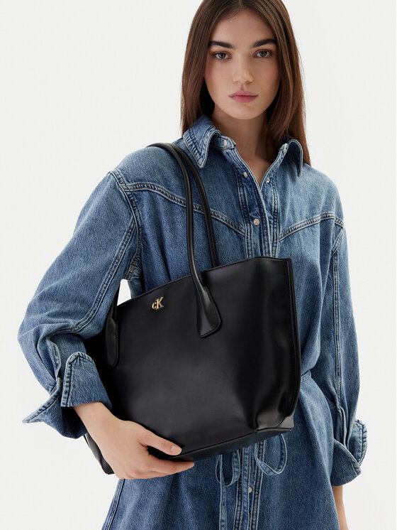 Modelka prezentująca torebkę shopper zawieszoną na ramieniu.