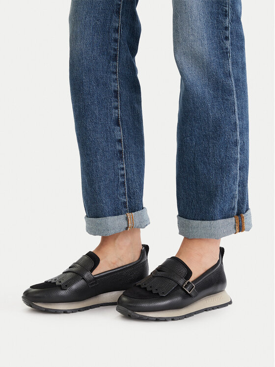 Model prezentujący buty na stopach, nogawki spodni widoczne w kadrze.