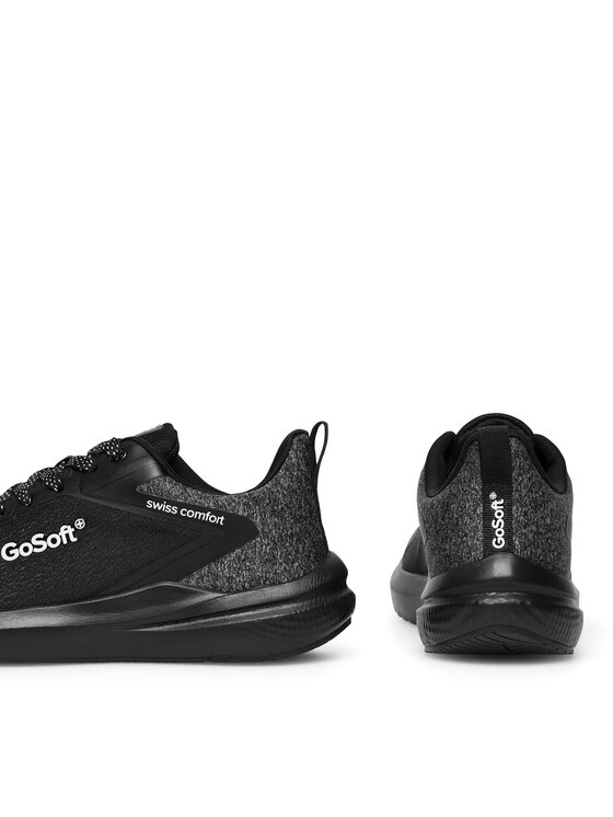 Dwa buty sportowe, jeden z boku, drugi od tyłu w kadrze.