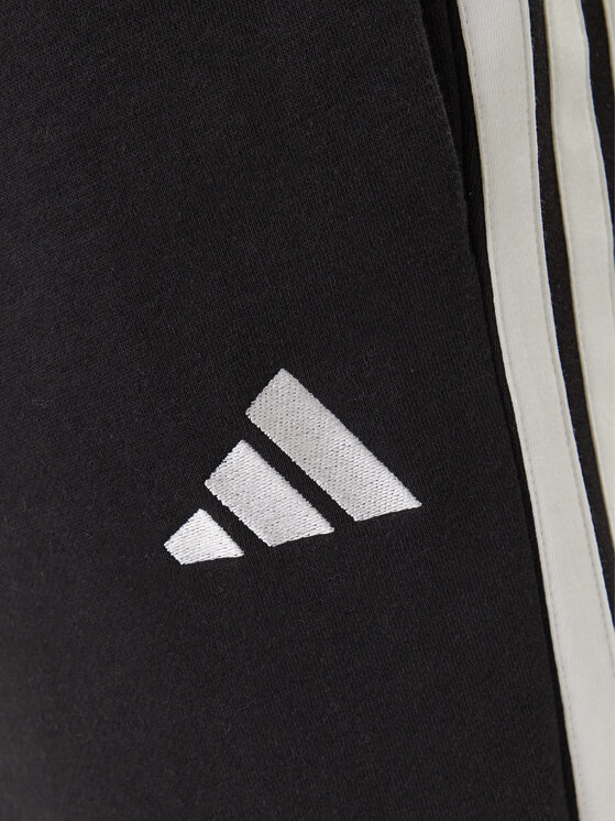 Zbliżenie na fragment nogawki spodni z widocznym logotypem.