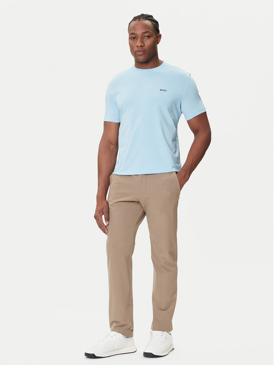Model w t-shircie i spodniach, ujęcie całej sylwetki pod lekkim kątem.