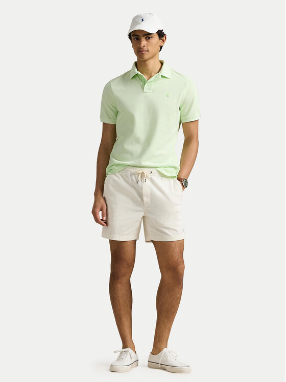 Model w koszulce polo i szortach, ujęcie całej sylwetki z przodu.