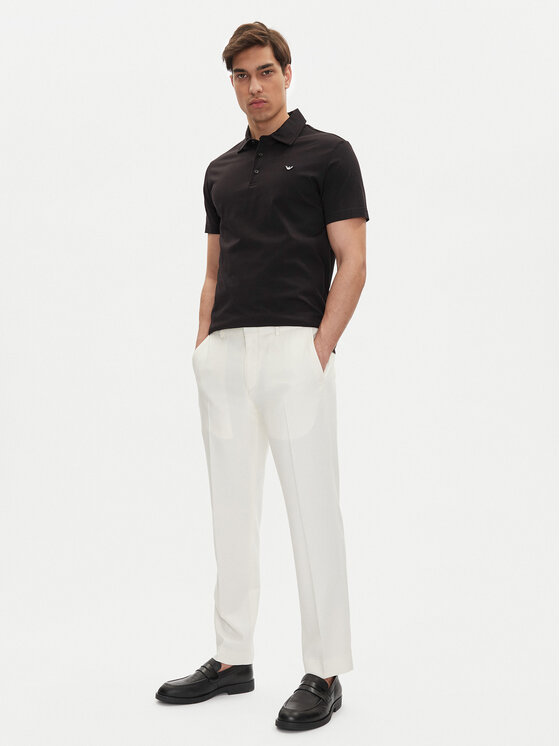 Model w koszulce polo i spodniach, ujęcie całej sylwetki z przodu.