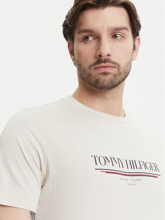 Zbliżenie na górną część T-shirta na modelu, widoczny nadruk z przodu.