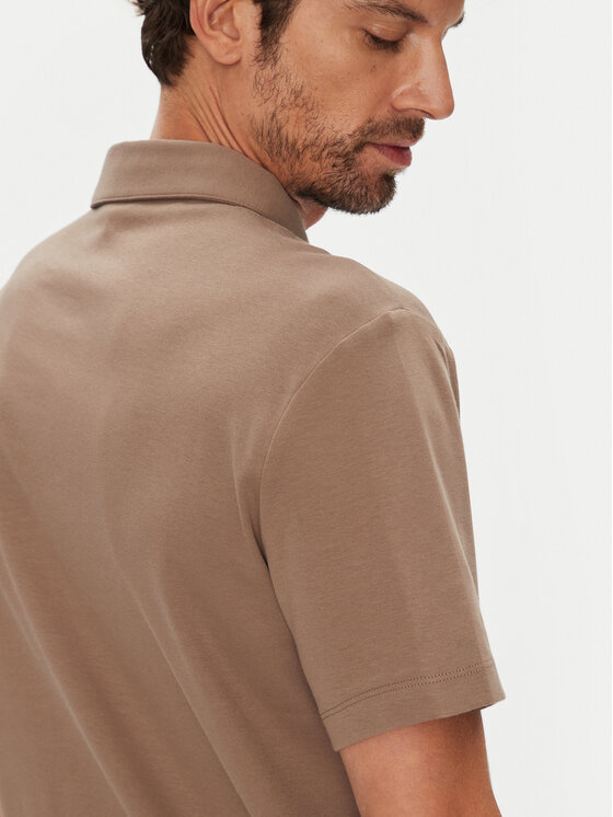 Zbliżenie na tylną górną część koszulki polo na modelu.