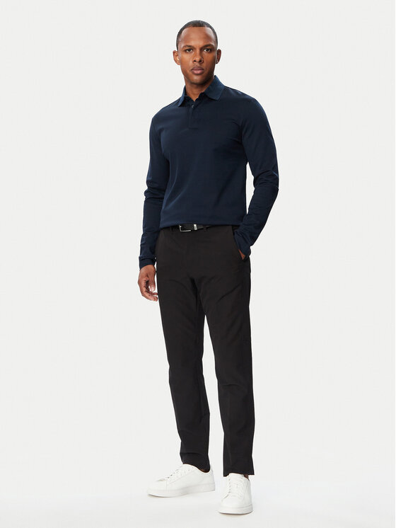 Model w pełnej sylwetce prezentujący koszulkę i spodnie.