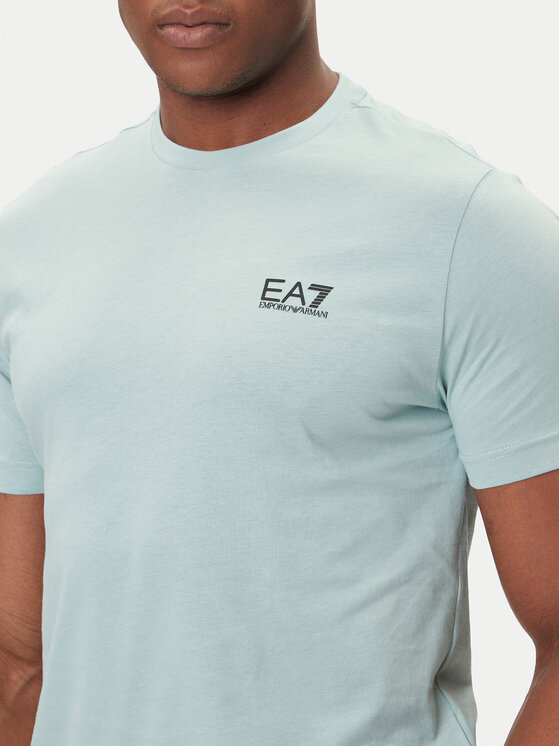 Zbliżenie na górną część T-shirtu na modelu, widoczny nadruk na piersi.