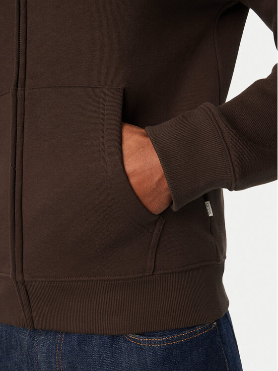 Zbliżenie na dolną część bluzy z kapturem, dłoń w kieszeni.