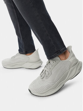 Stopy modela w spodniach, prezentujące buty widziane z boku podczas chodzenia.